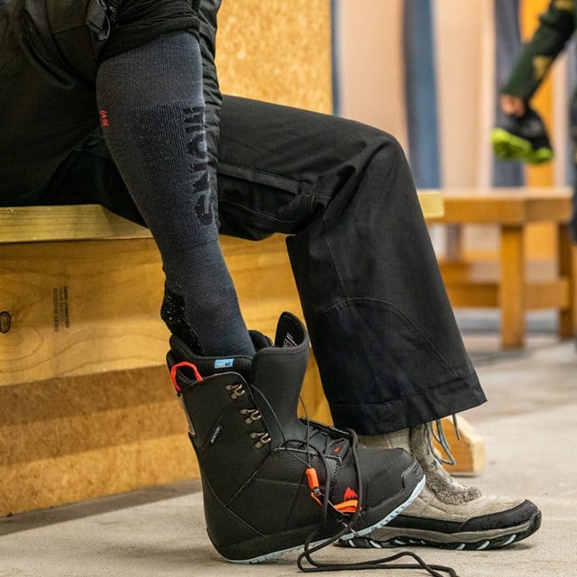Person slipping their foot into Snowboard boots