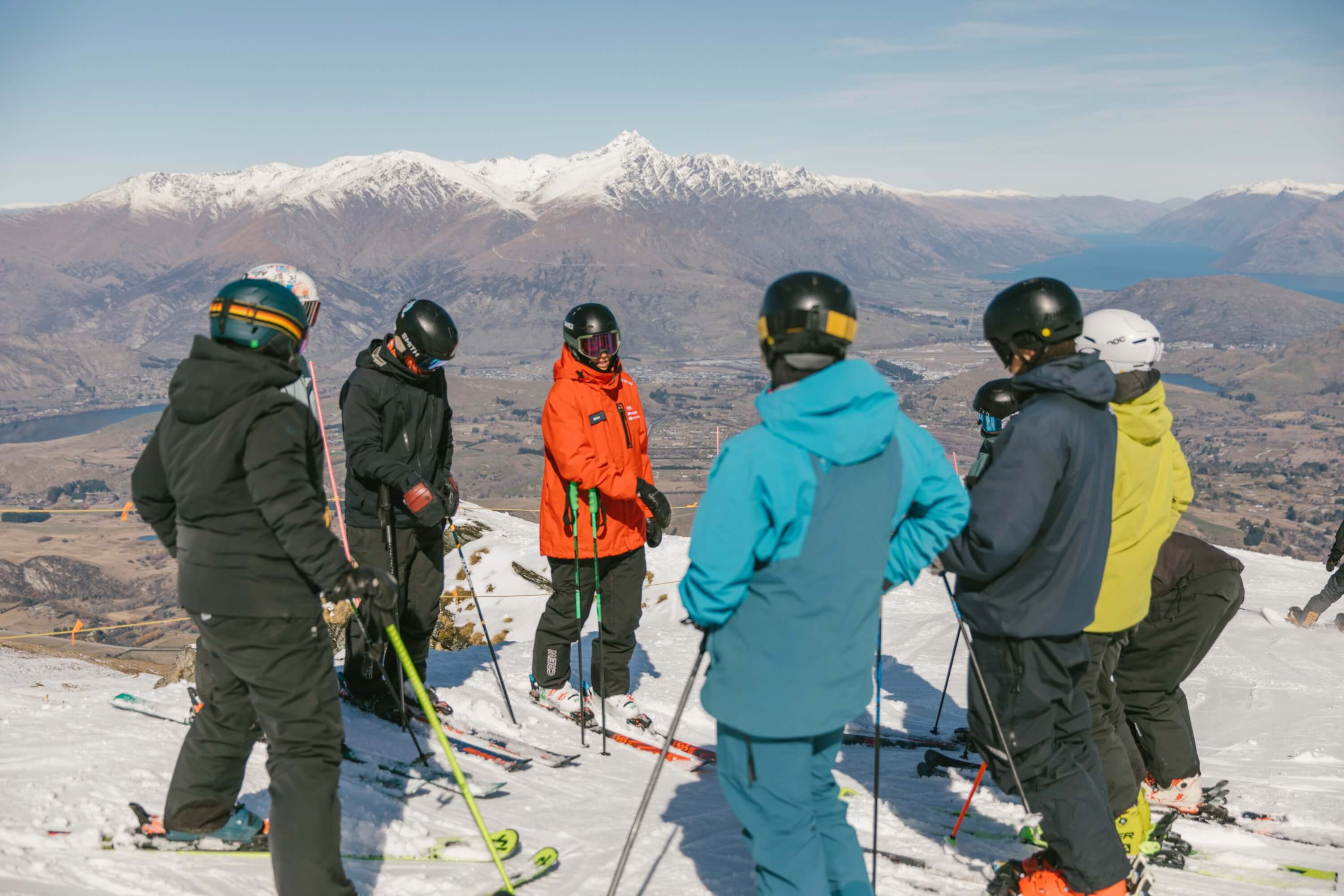 Instructor & skiers gathered in a circle for a lesson.